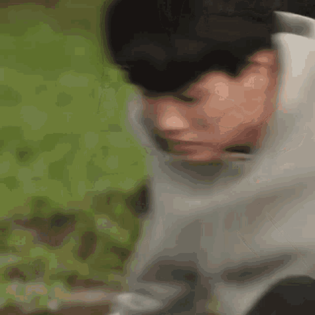 a young man in a hoodie is sitting on the ground .