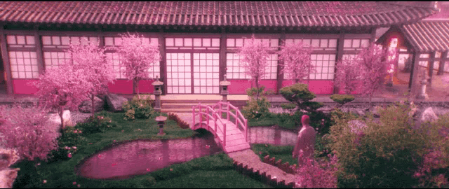 a man stands in front of a building with pink flowers