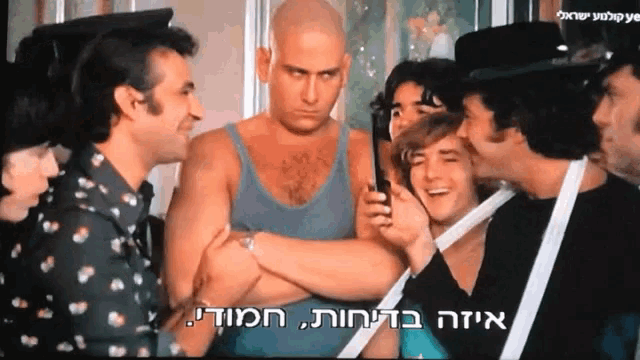 a group of men are standing in a room and one of them is holding a cellphone