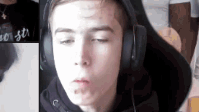 a young boy wearing headphones is making a face .