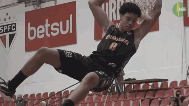 a basketball player is falling on the floor in front of a sign that says betsul