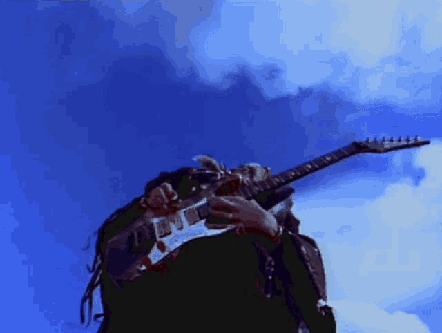 a man is playing a guitar in the sky