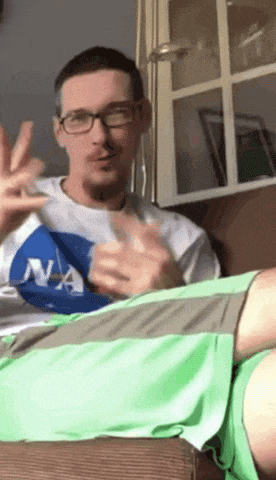 a man wearing glasses and a nasa shirt