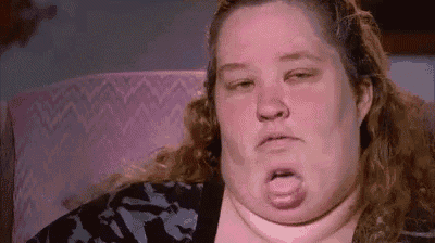 a woman with a very large neck is sitting in a chair with her mouth open .