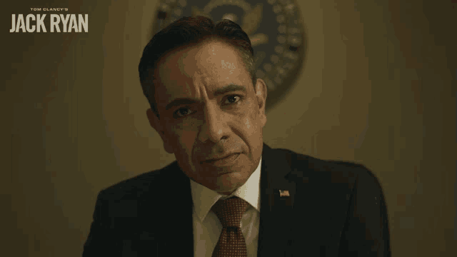 a man in a suit and tie with the name jack ryan on the bottom