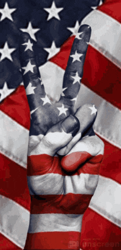 a peace sign is painted on a person 's hand in front of an american flag