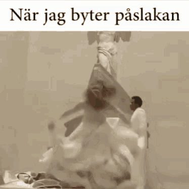 a picture of a man standing next to a statue with the words " när jag byter paslakan " above him