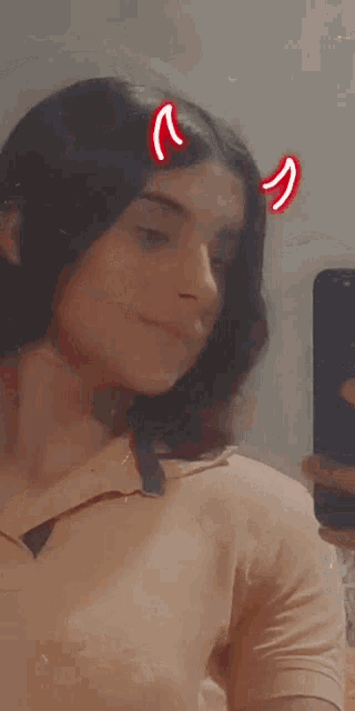 a girl with devil horns on her head takes a selfie