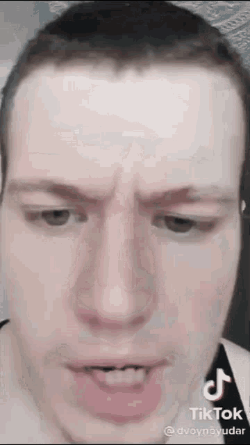 a man with a shaved head is making a funny face .