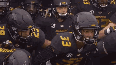 a group of football players are huddled together and one of them has the number 33 on their jersey