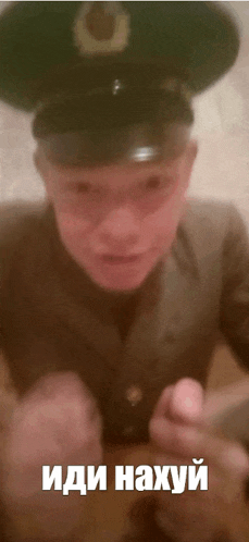 a man in a military uniform has a caption in a foreign language that says " иди нахуй "