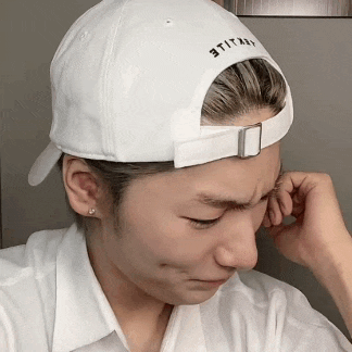a woman wearing a white baseball cap with the word utility on it