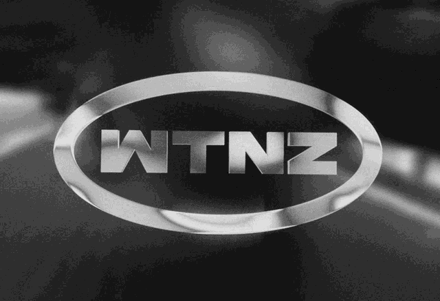 a black and white logo for wtnz in a silver oval