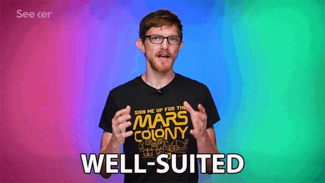 a man wearing glasses and a black shirt that says mars colony well suited