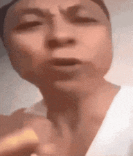 a close up of a person 's face with a white shirt on
