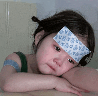 a little girl has a bandage on her forehead that says ' y ' on it