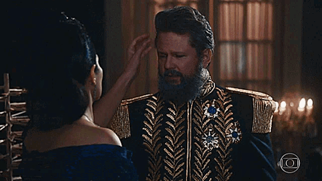 a woman in a blue dress is touching a man 's neck