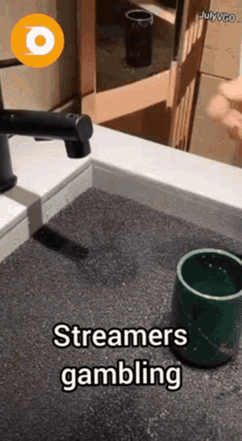 a bathroom sink with a green cup and the words streamers gambling