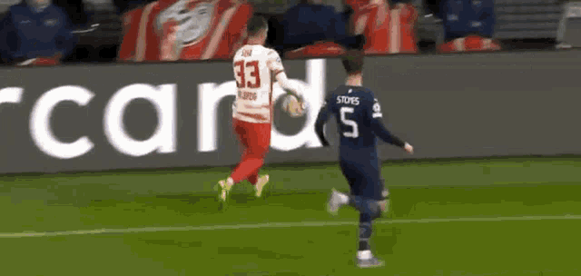 a soccer player with the number 5 on his jersey is holding a ball