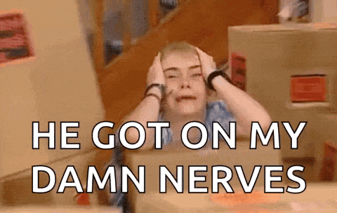 a woman is sitting in front of a box with her hands on her head and says `` he got on my damn nerves '' .