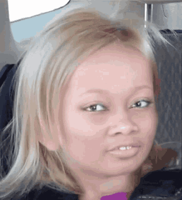 a close up of a woman 's face with blonde hair and green eyes