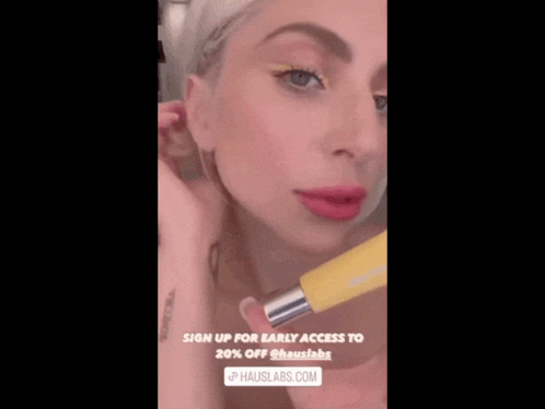 lady gaga is holding a yellow bottle with the words sign up for early access to 20 % off @hauslabs.com below her
