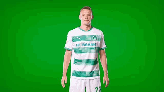 a man is wearing a green and white hofmann jersey