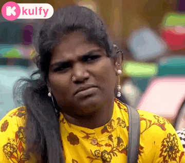 a woman in a yellow shirt with a floral print is making a funny face .