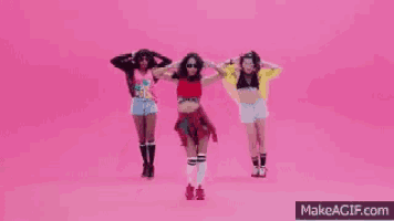 a group of three women are dancing on a pink background .