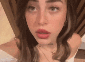 a close up of a woman 's face with red lipstick and a necklace .
