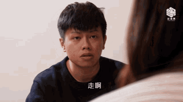a man with chinese writing on his face is talking to another person