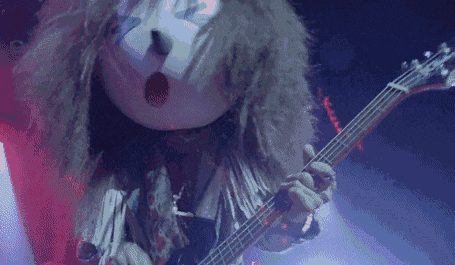 a close up of a person playing a guitar and wearing a mask