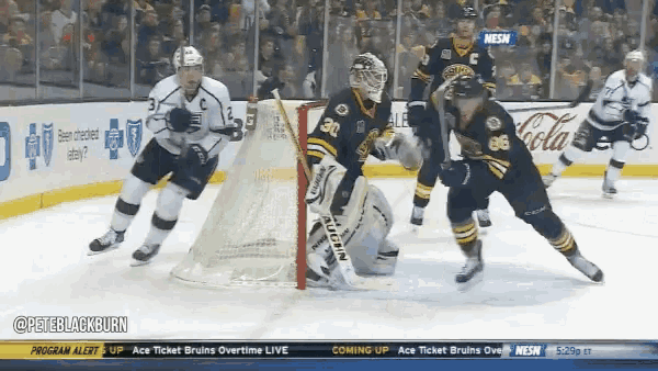 a hockey game is being played in front of a screen that says coming up ace ticket bruins overtime live