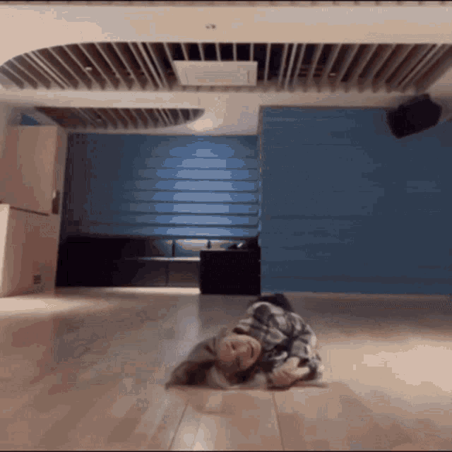 a person is laying on their back on the floor in a room with a blue wall