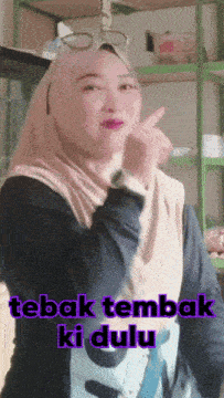 a woman wearing a hijab giving the middle finger with the words tebak tembak ki dulu behind her