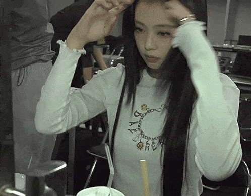 a woman wearing a white shirt that says ' a ' on it