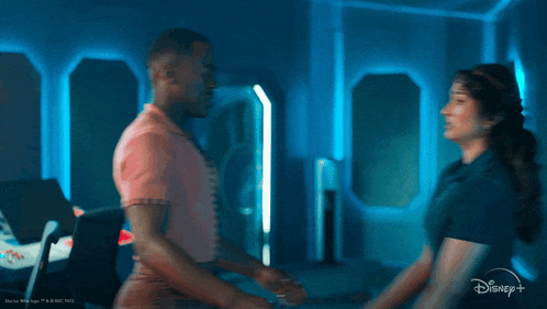 a man and a woman are holding hands in a room with a disney + logo in the corner