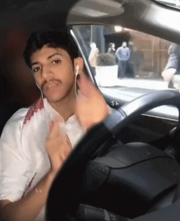 a man wearing ear buds is sitting in a car with the letters sh on the side
