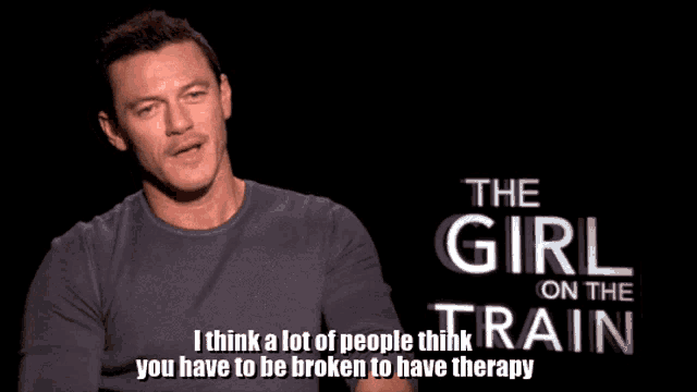 a man is talking in front of a sign that says the girl on the train