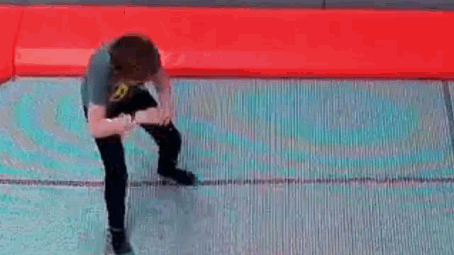 a young man is standing on a trampoline .