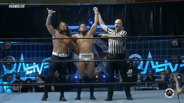 a wrestler is being congratulated by another wrestler in the ring