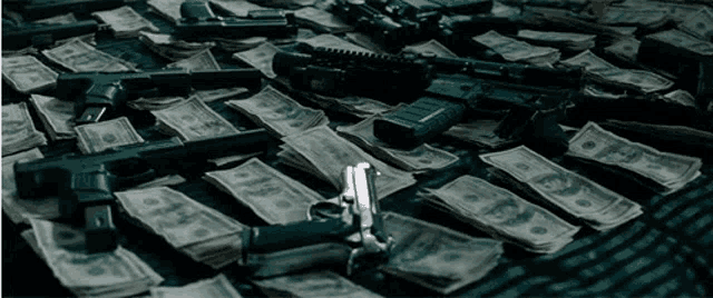 a bunch of money and guns are on a table
