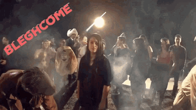 a woman stands in front of a crowd with the words bleghcome written on the bottom