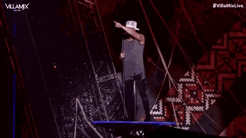 a man singing into a microphone on a stage with the villamix festival written on the bottom