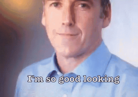 a man in a blue shirt is smiling and says `` i 'm so good looking '' .