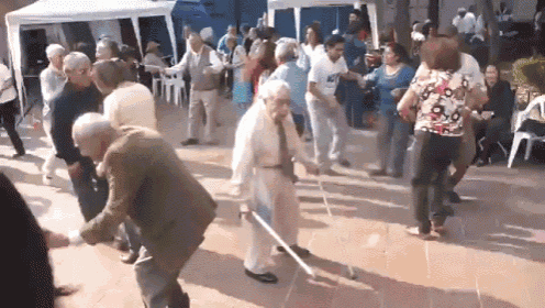 a group of elderly people are dancing in a crowd
