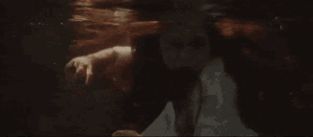 a woman is swimming underwater in a bathtub with her head above the water .
