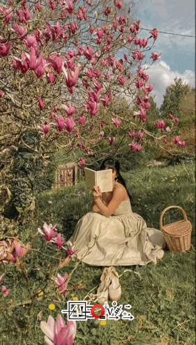 a woman in a white dress is reading a book under a tree