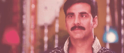 a man with a mustache is looking at the camera with a serious look on his face .