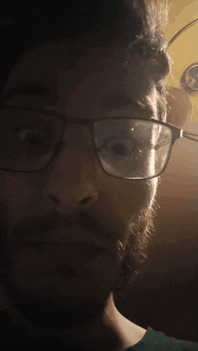 a close up of a man 's face with glasses